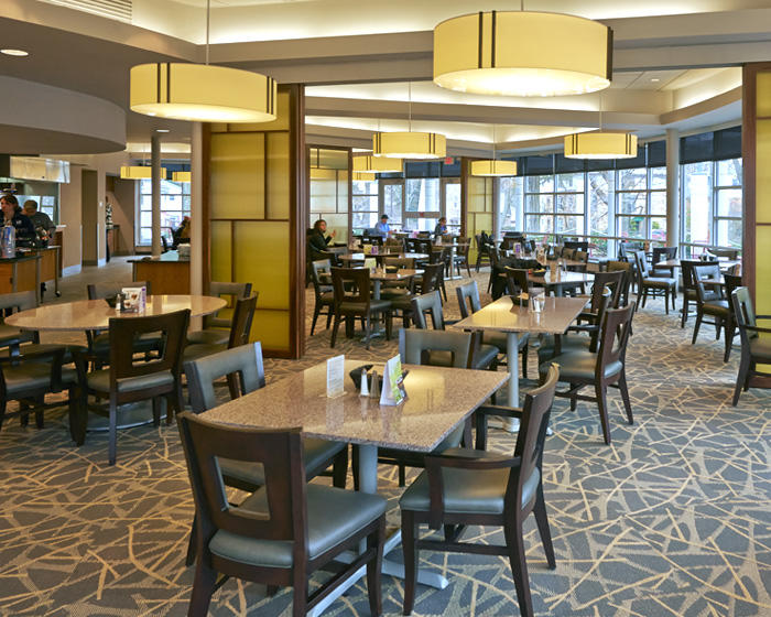 interior shot of Cafe Laura; people are eating in the background with empty, clean tables in the foreground